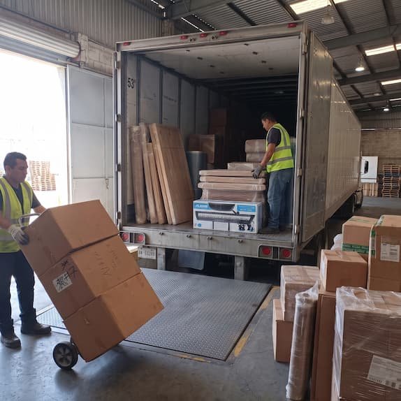 Personal cargando cajas en un camión completo para una mudanza a México