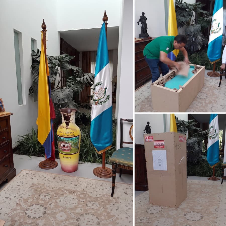 Banderas de Guatemala y Colombia junto a una caja de mudanza en trámite