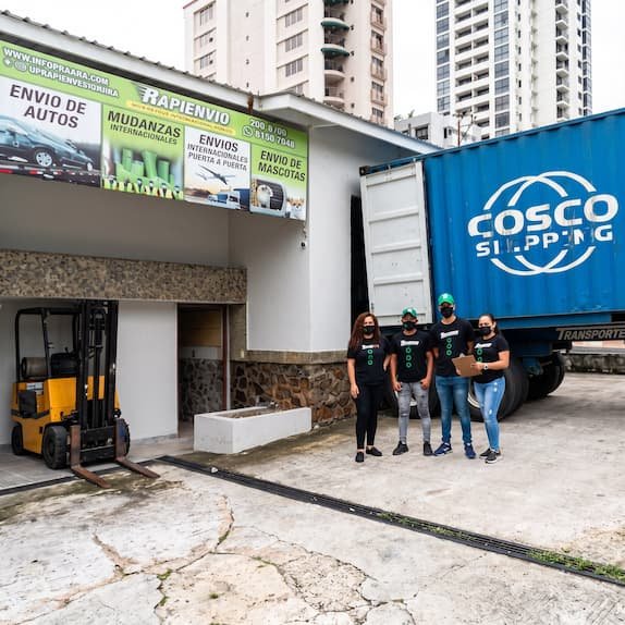 Personal de Rapienvio junto a un contenedor de envíos internacionales a Panamá