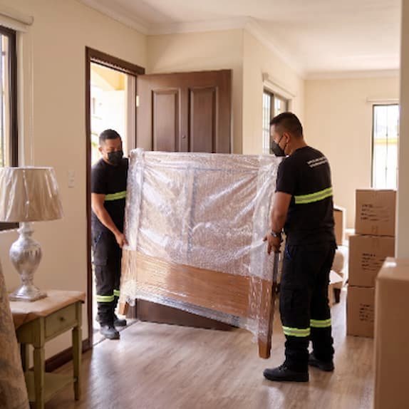 Personal de Rapienvio manejando con cuidado un mueble envuelto en plástico